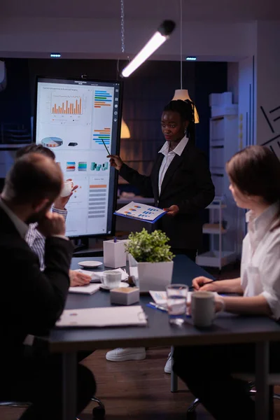 Affärskvinna med mörk hud som förklarar finansiella grafer med hjälp av presentationsmonitor — Stockfoto