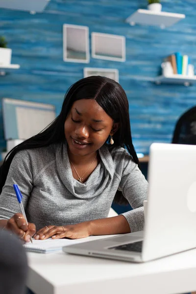 Afro-Amerikaanse student het schrijven van wiskunde huiswerk op notebook tijdens de middelbare school online klasse — Stockfoto