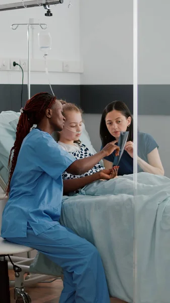 African american nurse showing lungs radiography explaining breathing disease symptoms — Stock Photo, Image