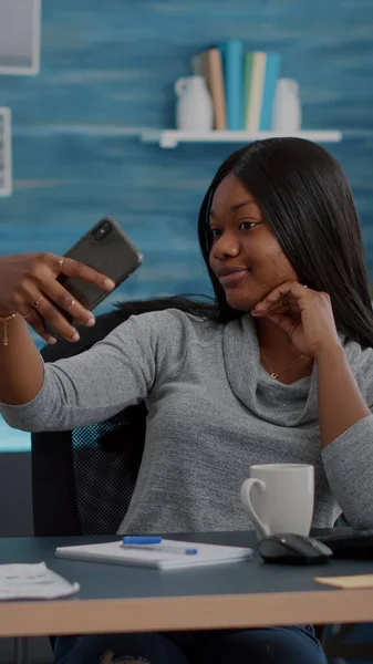 Atractivo estudiante negro sonriendo a la cámara mientras toma selfie con teléfono inteligente — Foto de Stock