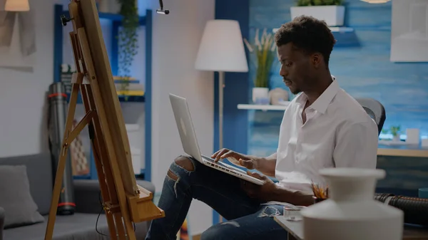Černý mladý umělec používající laptopovou technologii pro umělecký koncept — Stock fotografie