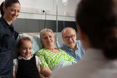 Doktor hasta yaşlı kadını kontrol ediyor. Sağlık tedavisini tartışıyorlar.