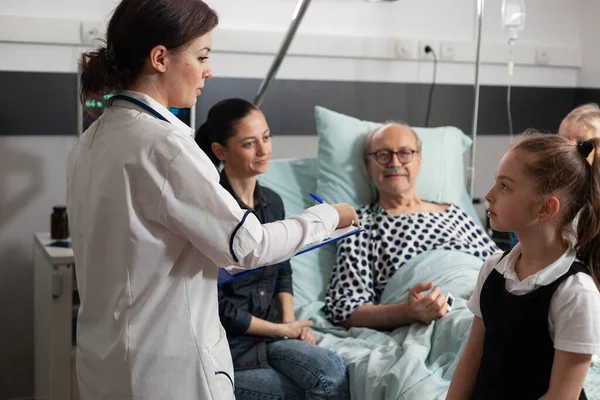 Практикующая женщина врач проверяет больного пожилого человека во время клинической терапии — стоковое фото