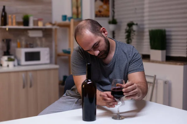 Blanke man met glas wijn in de keuken — Stockfoto