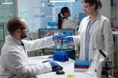 Biyokimya deneyinde çalışan mikrobiyoloji ekibi kan testini analiz ediyor.