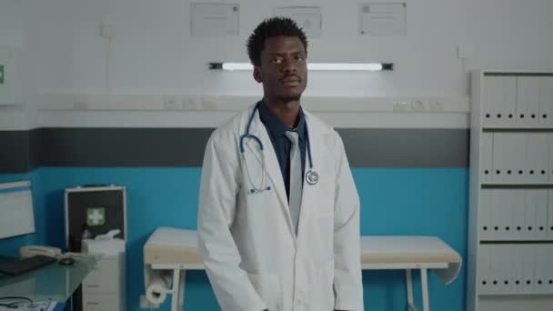 Retrato del médico afroamericano mirando a la cámara — Vídeo de stock