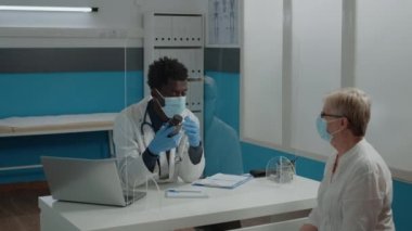 Doktor olarak çalışan adam elinde ilaç şişesi tutuyor.