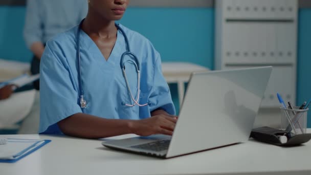 Закрыть африканскую американскую медсестру с помощью ноутбука — стоковое видео