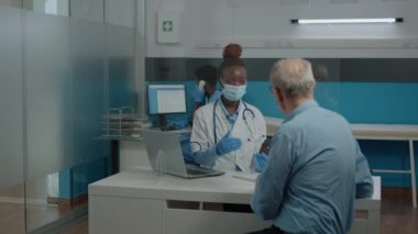 Siyahi profesyonel doktor ilaç şişesi gösteriyor.