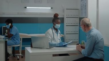 Doktor kontrol kağıtlarına bilgi yazıyor.