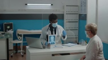 Siyahi doktor X ışını taramasıyla dijital tablet tutuyor