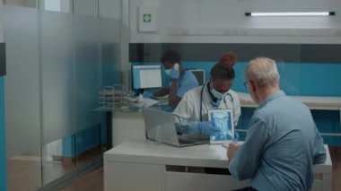 Genç doktor dijital tablet üzerinde röntgen analizi yapıyor.