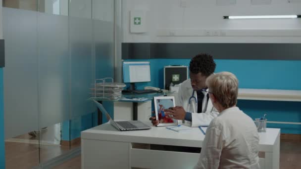 Especialista em cuidados de saúde explicando cardiograma na exposição do comprimido — Vídeo de Stock