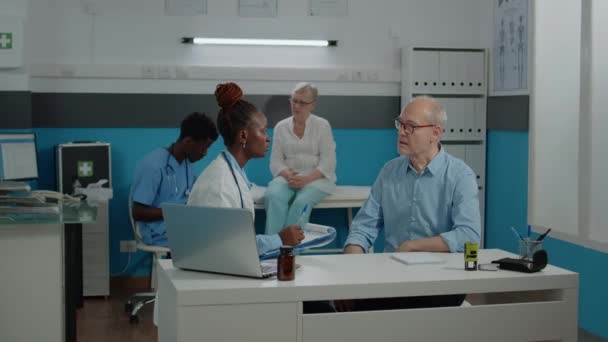 Az orvos ellenőrzi az idős betegek egészségügyi ellátását az orvosi szekrényben — Stock videók