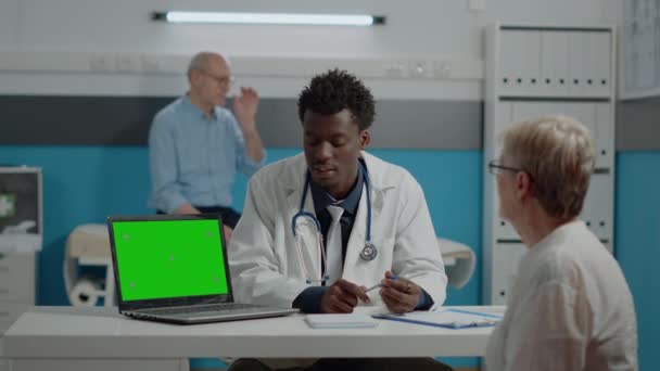 Młody medyk z laptopem z zielonym ekranem — Wideo stockowe