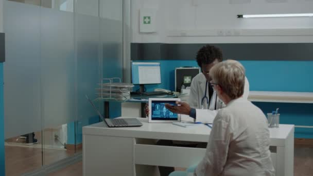 Jeune homme travaillant comme médecin montrant l'analyse virtuelle — Video