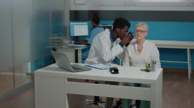 Kulak muayenesi için otoskop kullanan bir doktor.