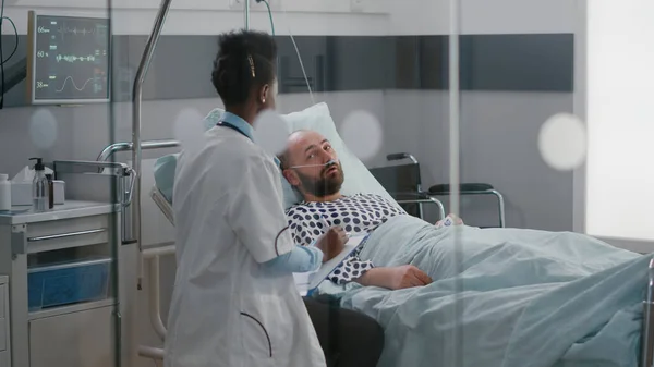 stock image Afro american doctor checking sick man monitoring sickness symptom