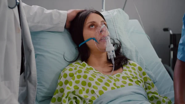 Nahaufnahme eines Arztes, der einer kranken Frau eine Sauerstoffmaske aufsetzt — Stockfoto