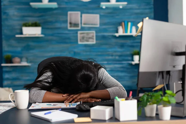 自宅から離れたリビングルームで机の上で寝ている失望した黒人学生 — ストック写真