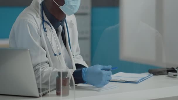 Крупним планом молодий лікар розмовляє з пацієнтом про охорону здоров'я — стокове відео