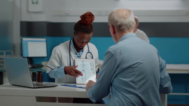 Spécialiste des soins de santé regardant tablette numérique avec vieux patient — Video