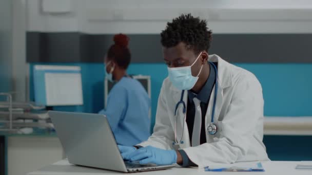 Retrato de jovem especialista usando laptop sentado na mesa — Vídeo de Stock