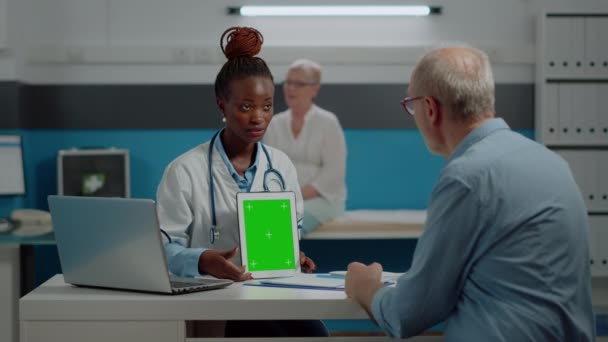 Médico mostrando tela verde no tablet para homem sênior — Vídeo de Stock