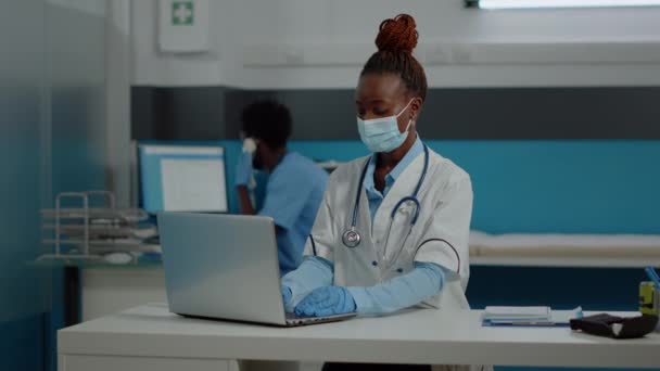 Portret młodego medyka korzystającego z laptopa na biurku — Wideo stockowe