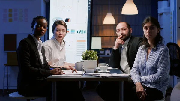 Mehrere multiethnische Geschäftsleute sitzen am Konferenztisch und diskutieren die Unternehmensstrategie — Stockfoto