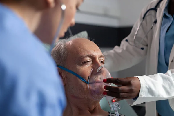 Zijaanzicht van senior patiënt ademhaling bijgestaan door respiratoire buis — Stockfoto