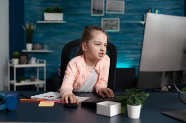 Yorgun ilkokul öğrencisi evden online derse katılıyor.
