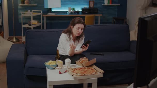 Empresária usando smartphone enquanto come fatia de pizza — Vídeo de Stock