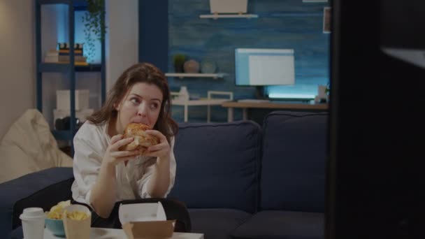 Mulher branca tomando mordida de hambúrguer e gole de refrigerante — Vídeo de Stock