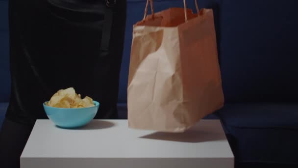 Közelkép az éhes emberről, amint kipakolja a gyorskaját — Stock videók