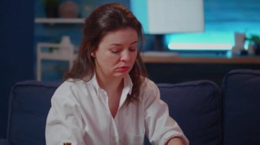 Oturma odasında hamburgerden ısırılan beyaz kadın.