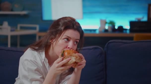 Primer plano de la mujer de negocios comiendo comida rápida en el sofá — Vídeo de stock