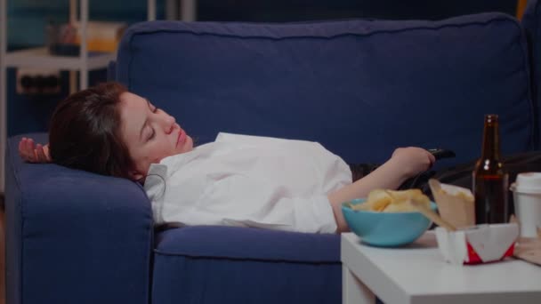Close up of sleepy woman laying on couch after eating — Stock Video