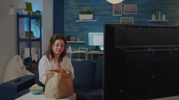 Young woman putting bag of takeaway food on table — Stock Video