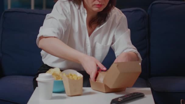Portrét hladové ženy jíst burger a dívat se na televizi — Stock video