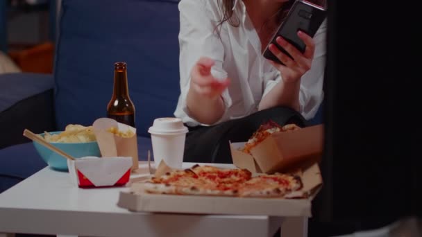 Kavkazská žena kousání plátek pizzy a držení smartphone — Stock video