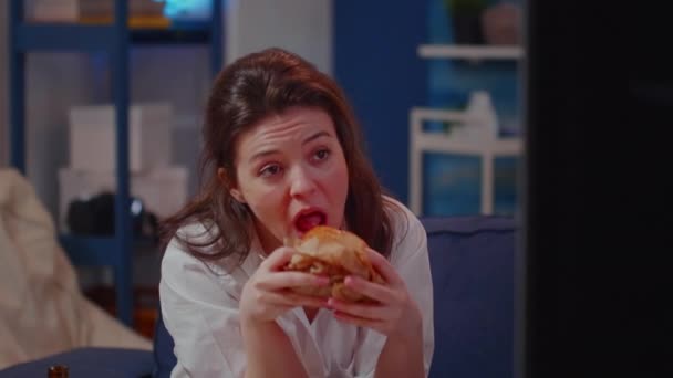 Retrato de una joven comiendo hamburguesa y bebiendo cerveza — Vídeos de Stock