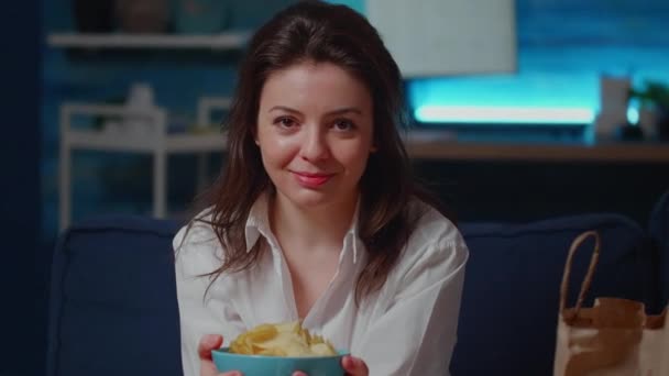 Porträtt av leende kvinna som håller skålen med chips i händerna — Stockvideo