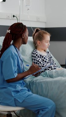 Afro-amerikan pratisyen asistan hasta belirtilerini panoya yazıyor.