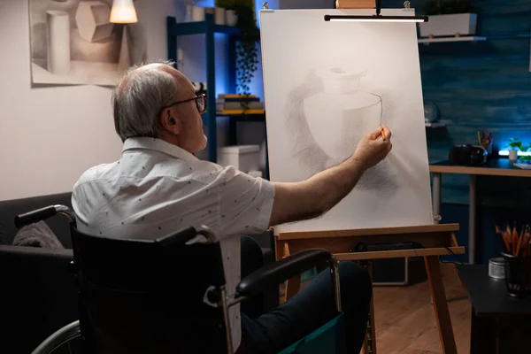 Старший художник с инвалидностью рисует вазу с карандашом — стоковое фото