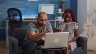 Modern ırklar arası çiftler dizüstü bilgisayar ve defterle vergi beyan ediyorlar.