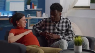 Hamilelik hakkında konuşan ırklar arası genç bir çift.