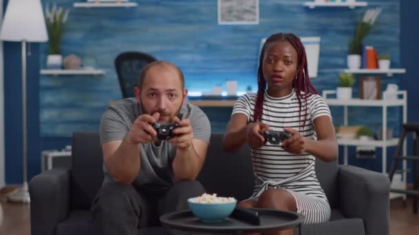 Casal interracial moderno jogando videogame na TV — Vídeo de Stock