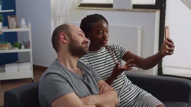 Casal interracial conversando e acenando em videoconferência — Vídeo de Stock