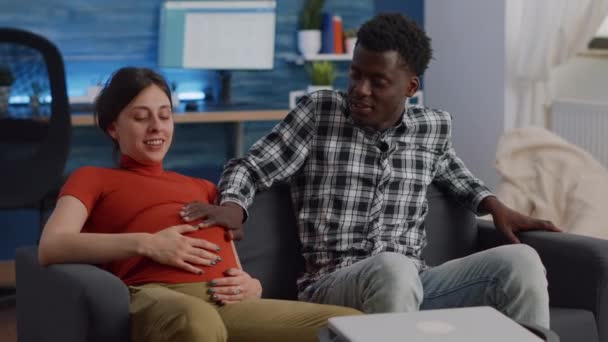 Женатая межрасовая пара ждет ребенка, сидящего дома — стоковое видео